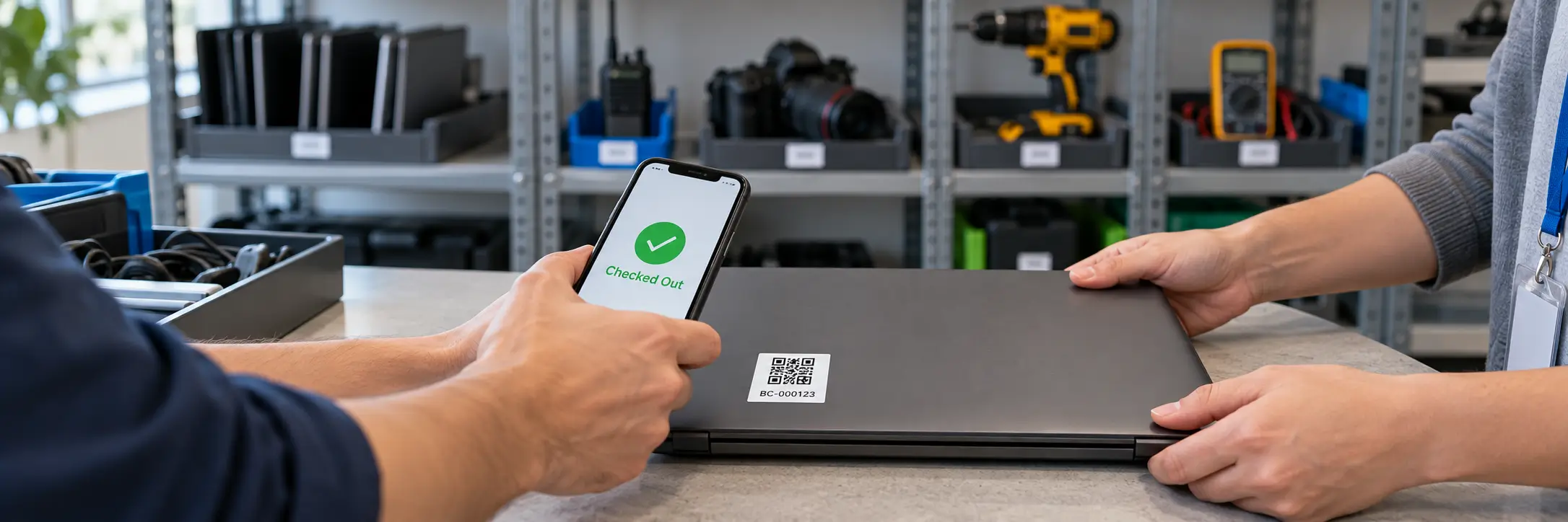 laptop-qr-asset-tag-checked-out Employee scanning a QR code asset tag labeled BC-000123 on a laptop with a phone showing "Checked Out," as a colleague hands it over in an equipment room